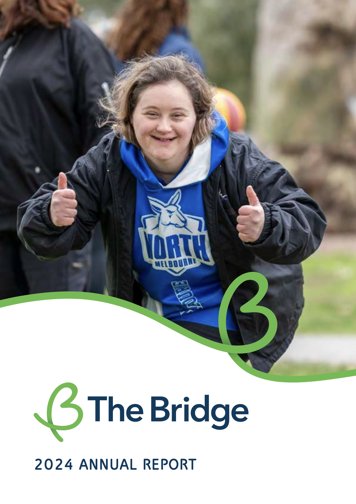 Woman smiling, giving two thumbs up, wearing a North Melbourne hoodie. The Bridge 2024 Annual Report cover.