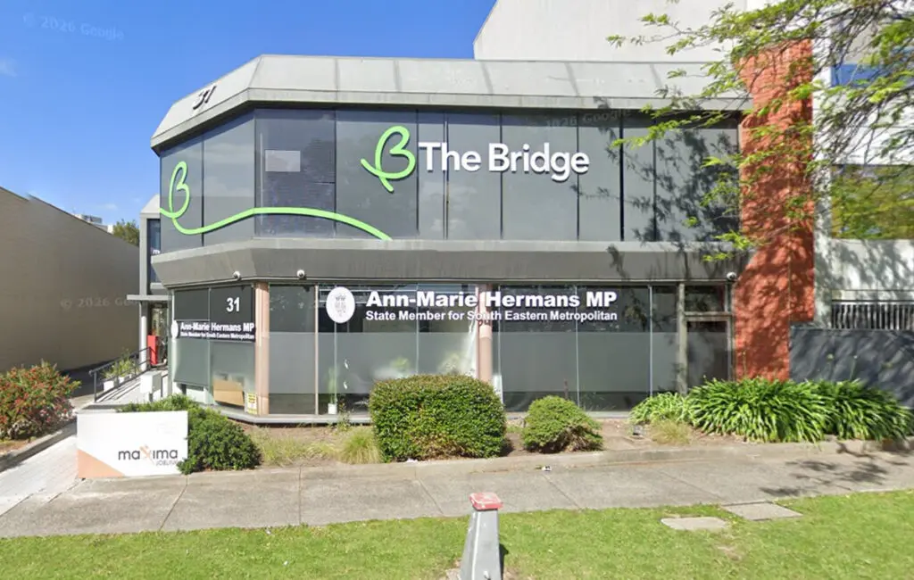 Two-storey office building with 'The Bridge' signage upstairs and Ann-Marie Hermans MP office signage below.