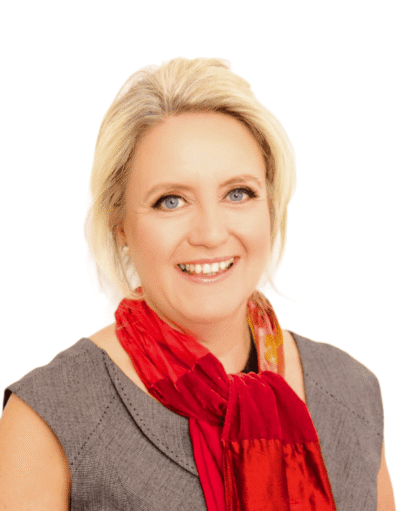 Woman with blonde hair smiling, wearing a grey top and red scarf, against a white background.