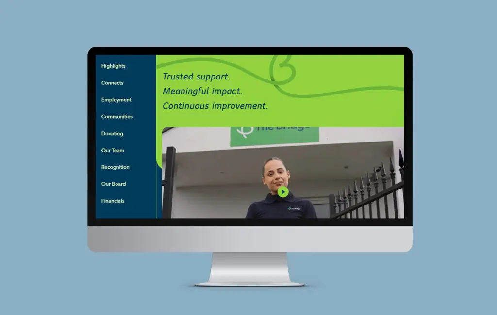 Monitor showing a website with a side menu, text 'Trusted support, Meaningful impact', and a video thumbnail of a woman.