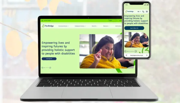 Laptop and phone showing The Bridge website homepage, with a woman gesturing, and text about supporting people with disabilities.