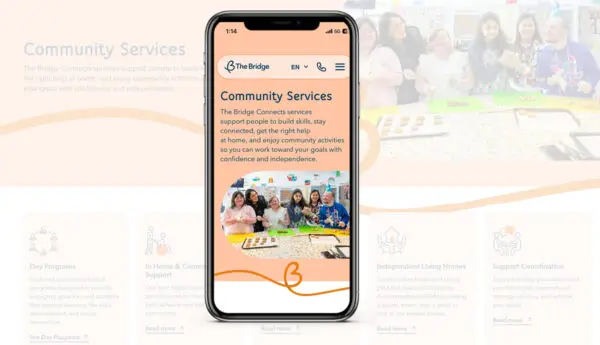 Phone showing The Bridge website Community Services page, with group photo and service category icons behind it
