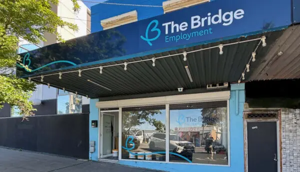 Street-level shopfront with blue awning reading 