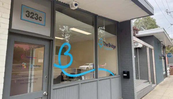 Shopfront at 323c with The Bridge Employment signage and logo on window glass.