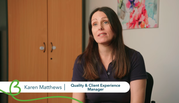 Karen Matthews, Quality & Client Experience Manager, speaking during a video interview in an office.